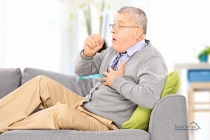| Air Conditioning Specialists Man seated on a sofa coughing