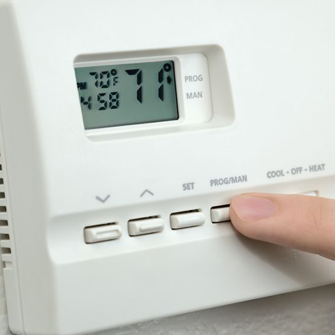 closeup of someone adjusting home thermostat