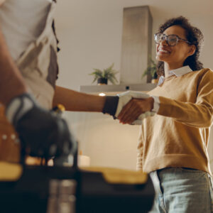 Woman shaking hands with her choice of AC contractor