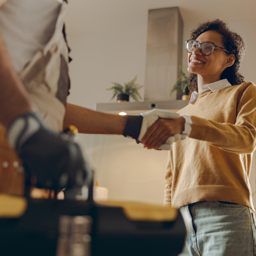 Woman shaking hands with her choice of AC contractor