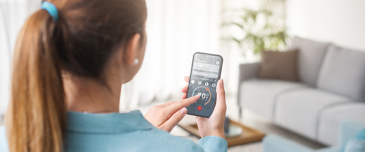 woman using smart phone app to operate her HVAC unit