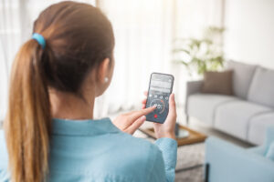 woman using smart phone app to operate her HVAC unit